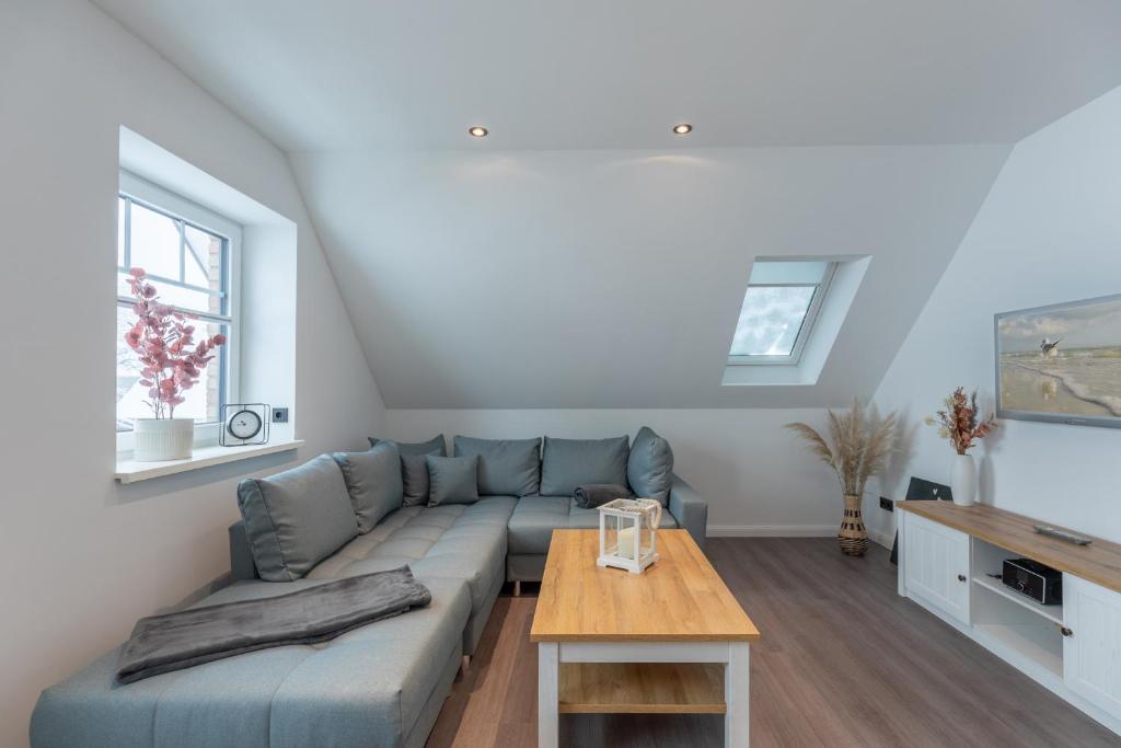 a living room with a blue couch and a table at Langeneß in Hattstedt