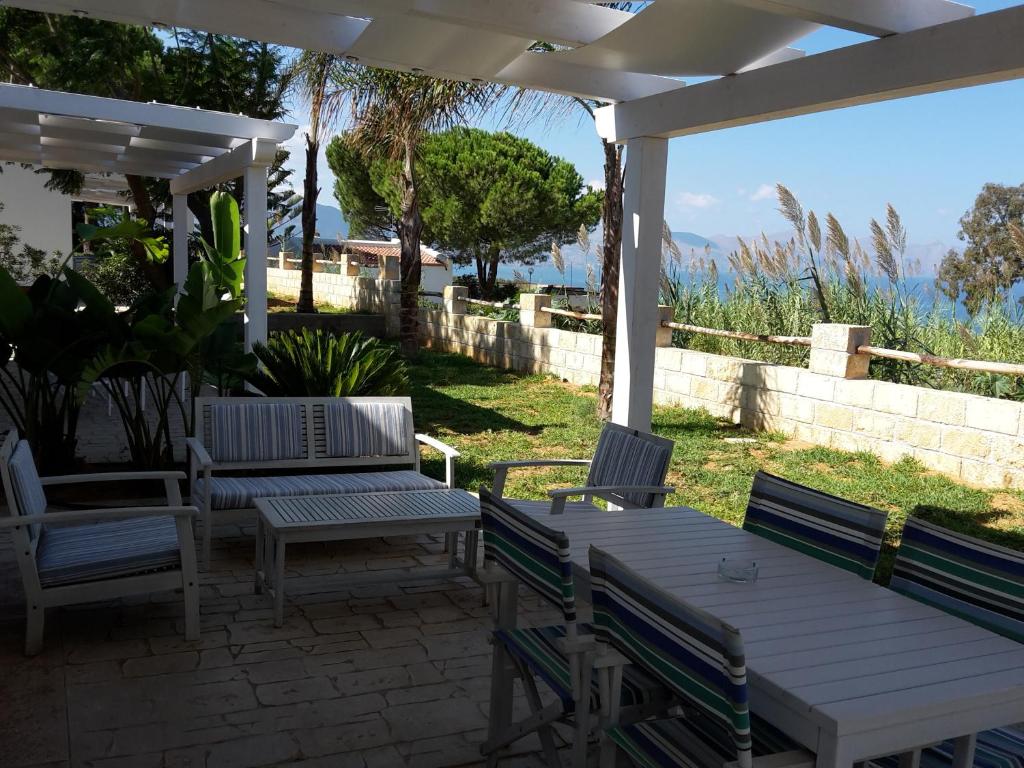 a patio with a table and chairs under a pergola at Petruso Resort in Balestrate