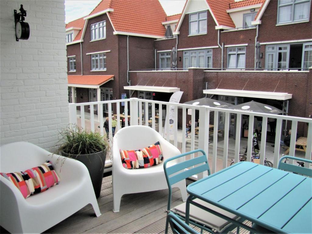 a balcony with two chairs and a table at Luxury apartment in Koudekerke with sauna in Koudekerke