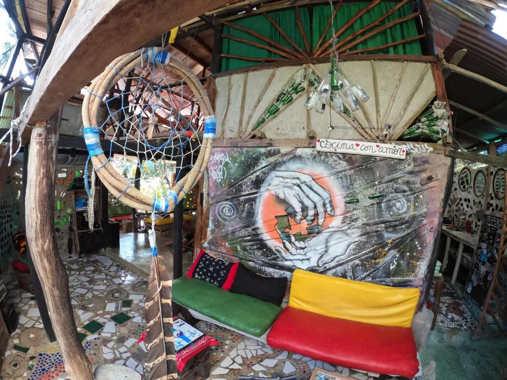 een kamer met een stoel en een schilderij aan de muur bij Reciclarte Galería Hostal in Capurganá