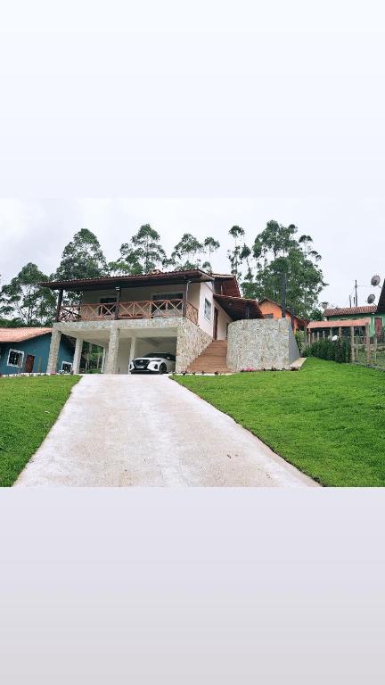 a large house with a driveway in front of it at A Casa do Júnior em Visconde de Mauá in Visconde De Maua