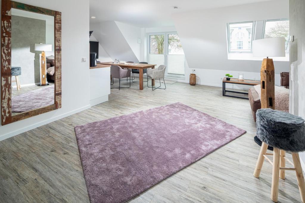 ein Wohnzimmer mit einem großen Spiegel und einem Tisch in der Unterkunft Salt and Sea in Norderney