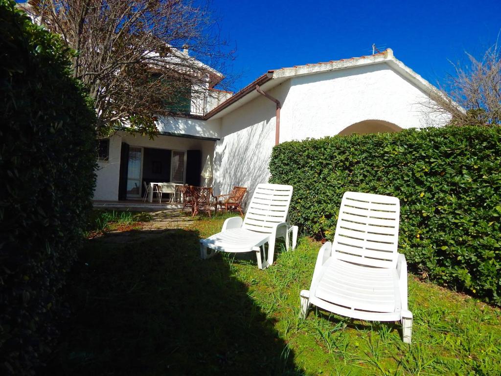dos sillas blancas sentadas en el césped frente a una casa en N107 - Numana, villetta con giardino, en Numana