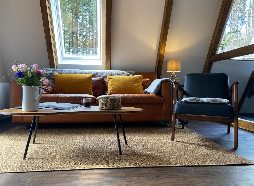 sala de estar con sofá y 2 sillas en Wald-Chalet Vulkaneifel, en Kerschenbach