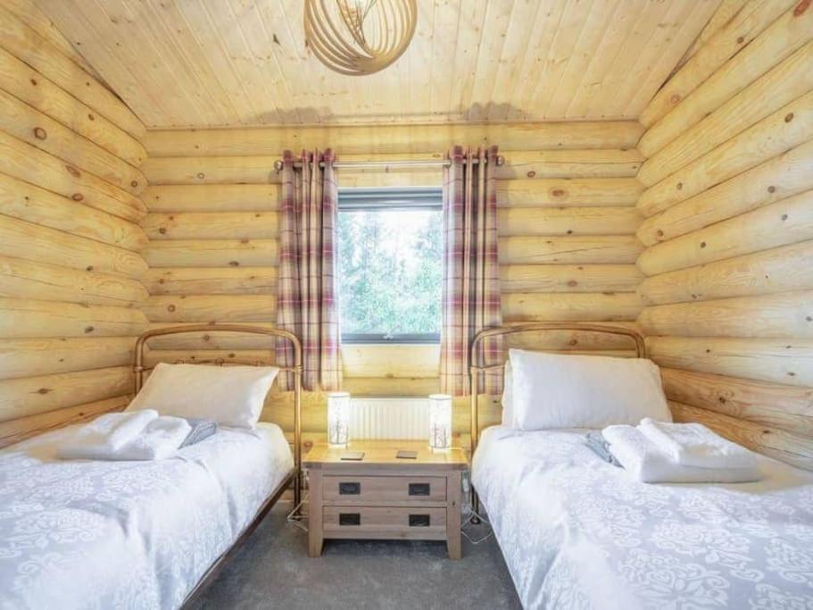 Postel nebo postele na pokoji v ubytování Treetops Luxury Log Cabin - Hot tub, BBQ & Sauna
