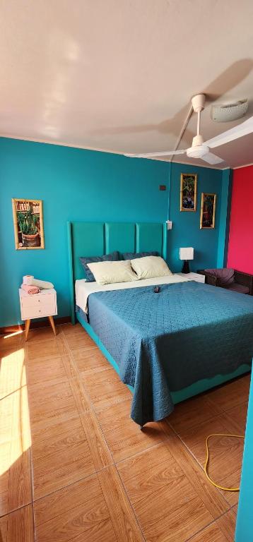 a bedroom with a large bed with blue and red walls at La Casa de Bamboo in Ica
