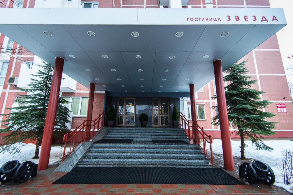 una escalera que conduce a un edificio con nieve en el suelo en Zvezda Hotel, en Minsk