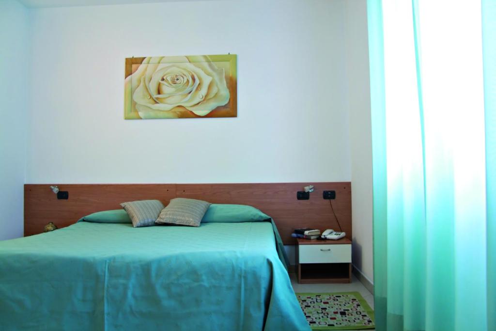 a bedroom with a blue bed with a white rose at Residence La Casetta in Loano