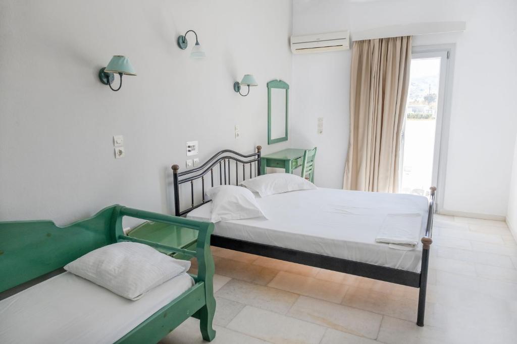 a bedroom with two beds and a window at Korali Garden in Naxos Chora