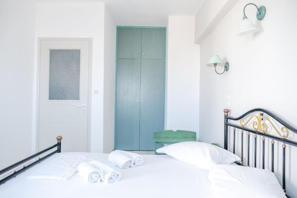 a bedroom with a bed with white sheets and a blue cabinet at Korali Garden in Naxos Chora