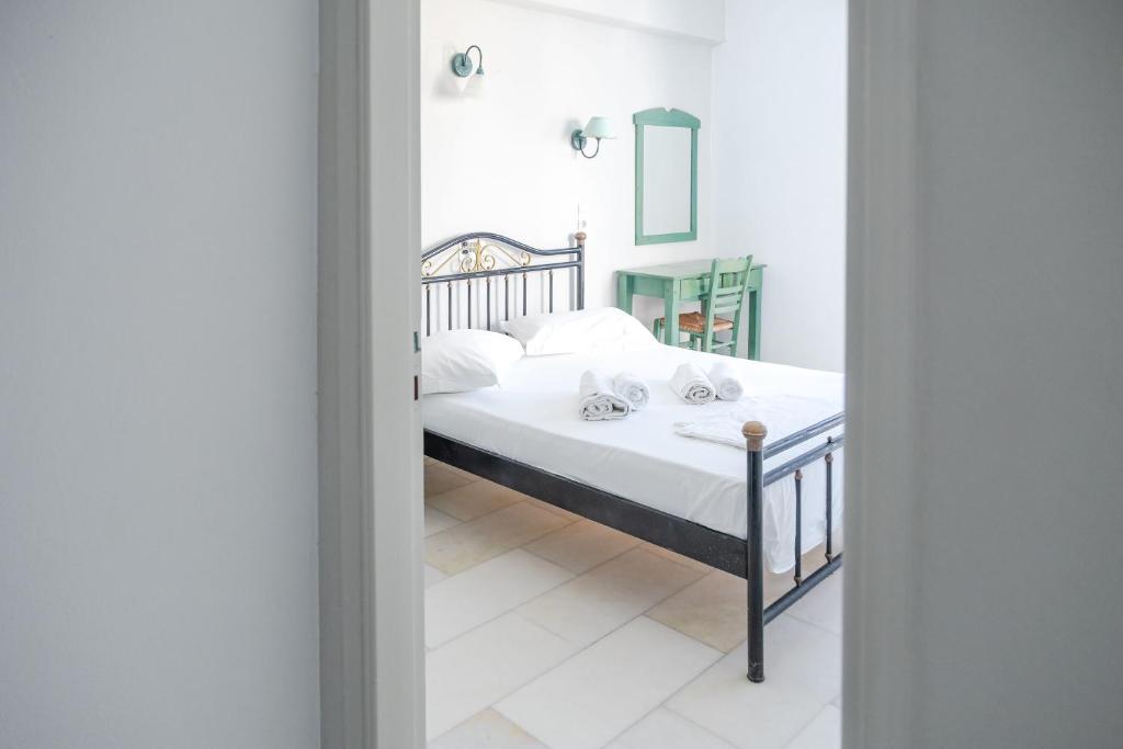a bedroom with a bed with white sheets and white pillows at Korali Garden in Naxos Chora