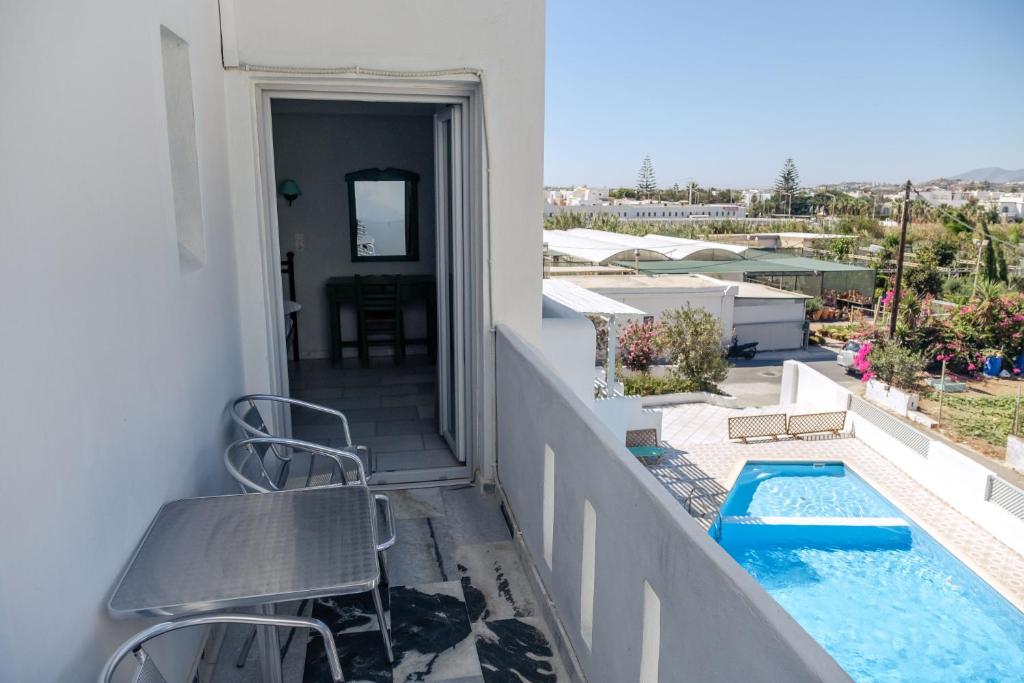 a balcony with chairs and a swimming pool on a building at Korali Garden in Naxos Chora
