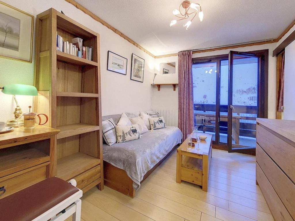 Cette petite chambre comprend un lit et une étagère. dans l'établissement Appartement confortable avec cabine Proche des pistes Balcon - FR-1-344-1148, aux Menuires