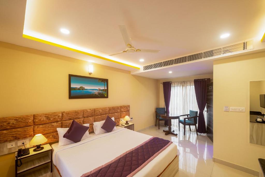 Zenith Hotels Hebbal Bangalore في بانغالور: غرفة في الفندق مع سرير ومكتب