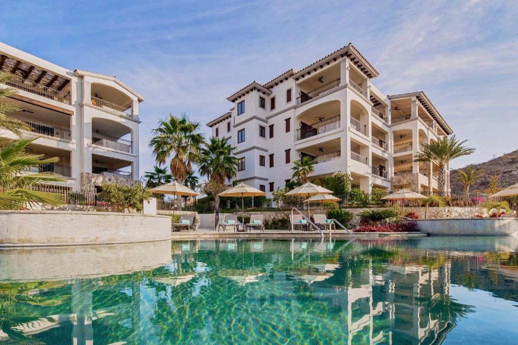 um hotel com piscina em frente a um edifício em Live Aqua Private Residences Los Cabos em Cabo San Lucas