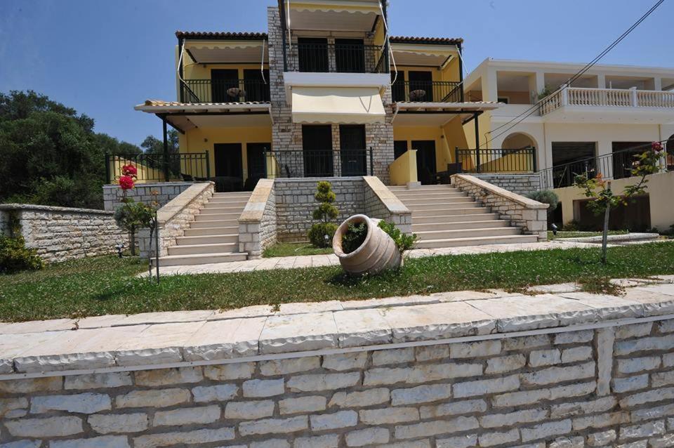 een huis met een bakstenen muur en een trap bij Koronisia Apartments in Koronisía