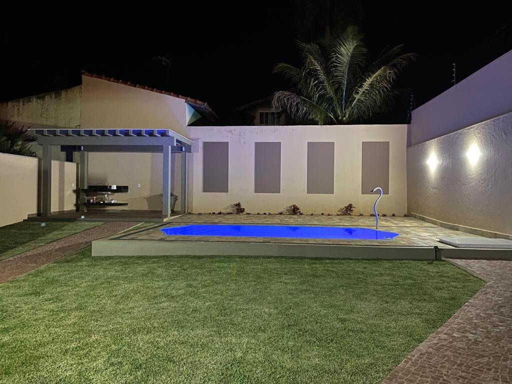 a swimming pool in the yard of a house at night at Cantinho Aconchegante 2 in Brotas