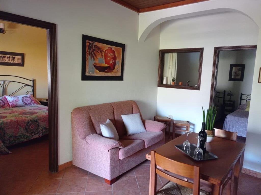 a living room with a couch and a table and a bed at Apartamento La Punta in Alojera