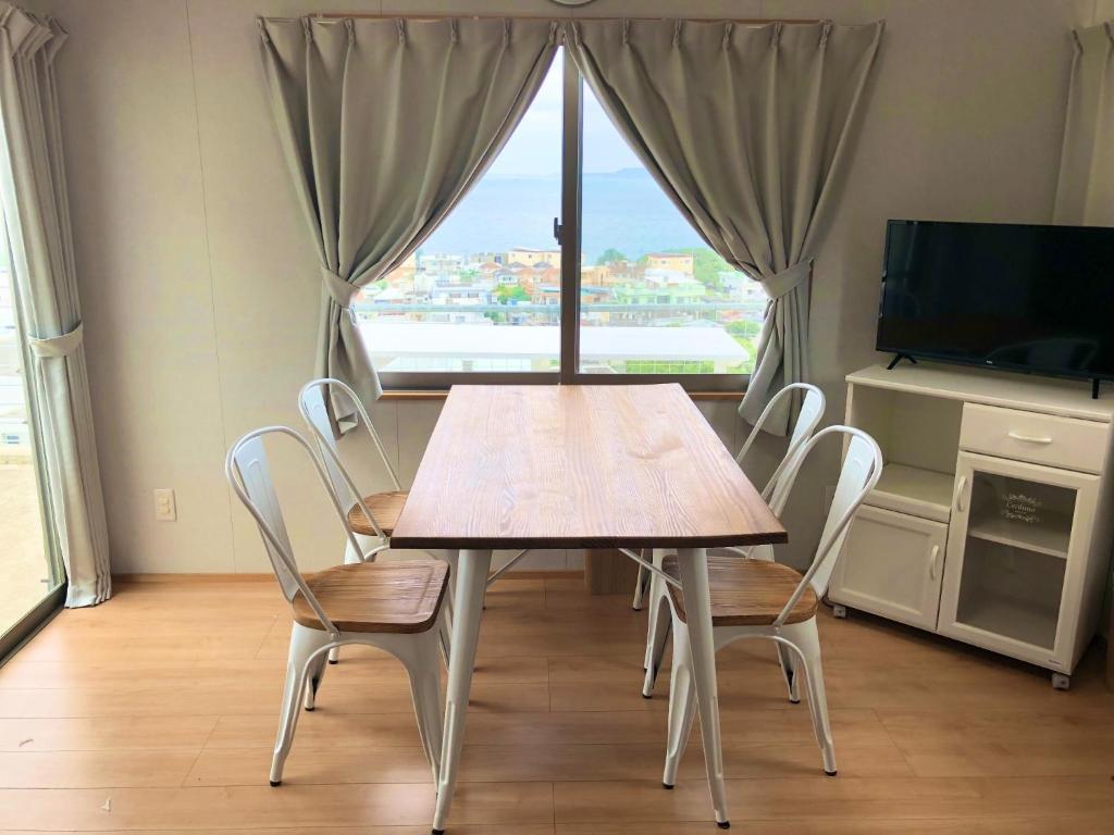 - une table et des chaises dans une chambre avec fenêtre dans l'établissement Guest House Marine View - Vacation STAY 62152v, à Uruma