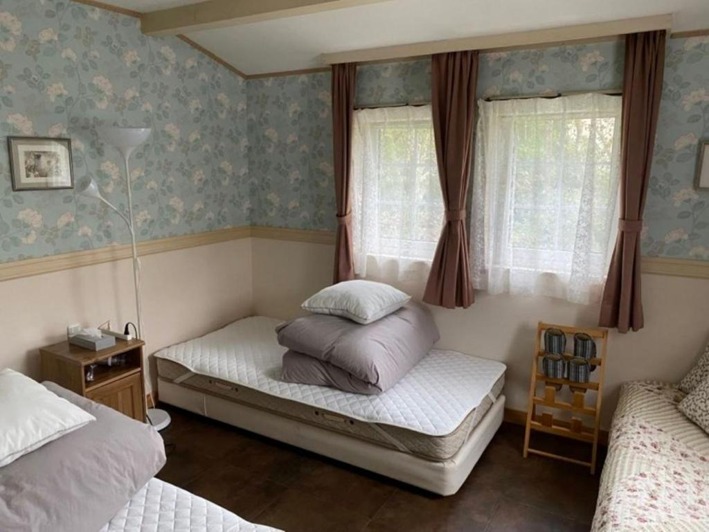 een slaapkamer met 2 bedden en 2 ramen bij Ashigarashimo-gun - Hotel - Vacation STAY 53655v in Onsensō