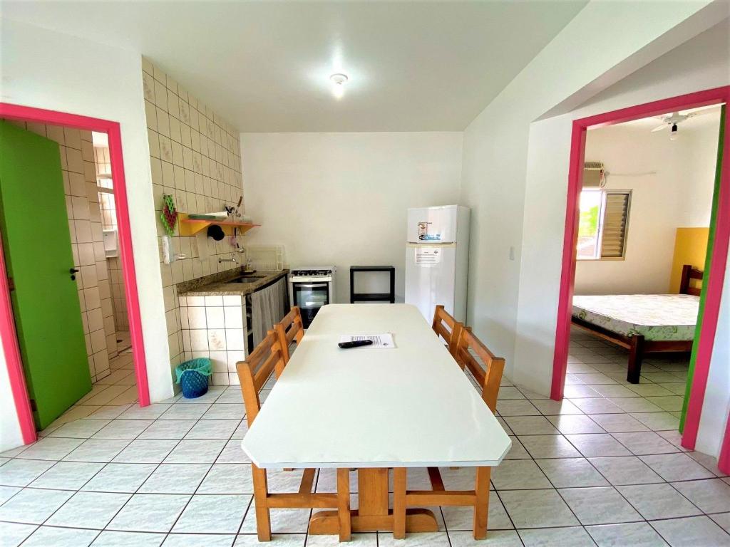 a kitchen with a table and chairs in a room at Chalés Sununga Flats a 1 minuto da praia in Ubatuba