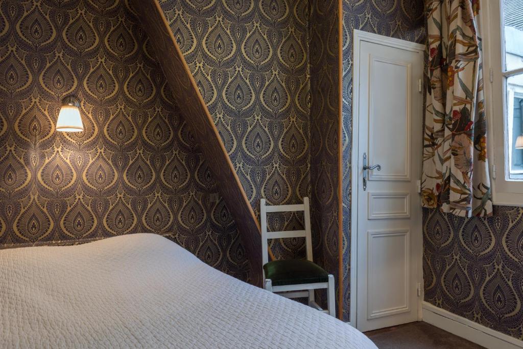 a bedroom with a white bed and a staircase at Hotel Esmeralda in Paris
