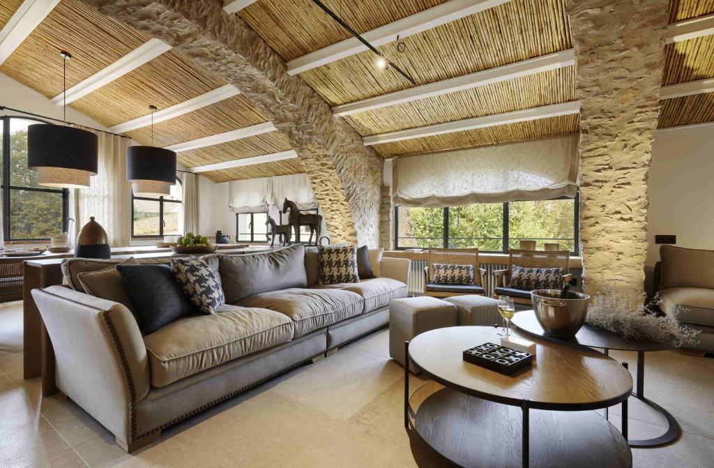 ein Wohnzimmer mit einem Sofa und einem Tisch in der Unterkunft Turisme Rural Mas Ametller - Casa Gran in Fontclara