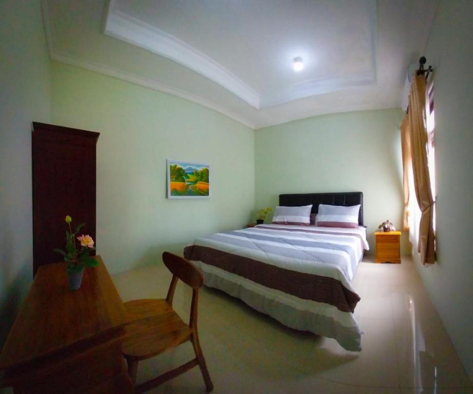 um quarto com uma cama grande e uma mesa de madeira em Gated 3BR Residence - 10 mins from Malioboro em Yogyakarta