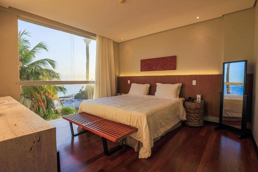 a bedroom with a bed and a large window at Zank by Toque Hotel in Salvador