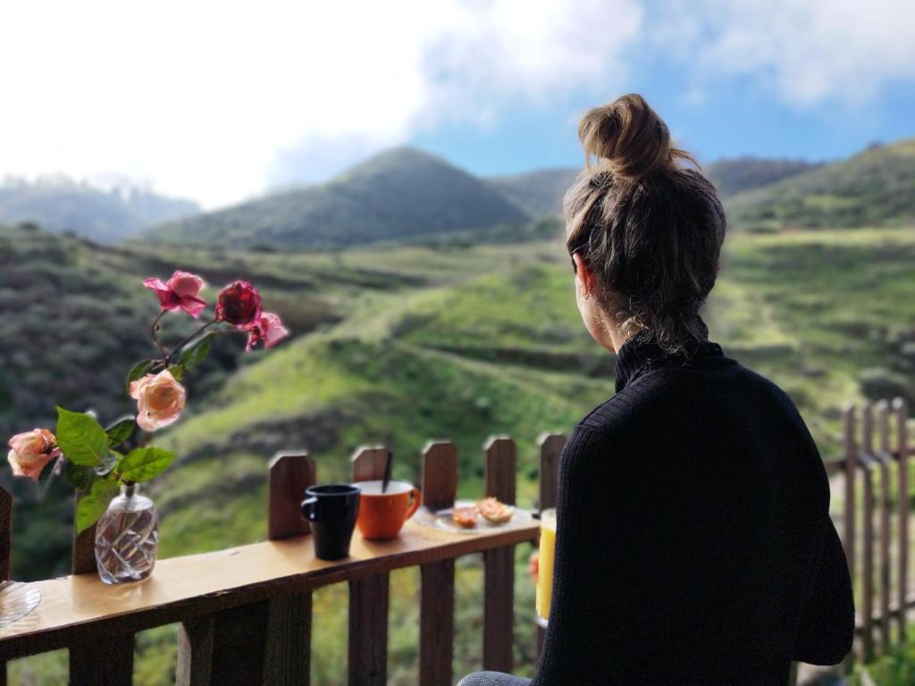 een vrouw aan een tafel met uitzicht op de bergen bij La Casita in Vega de San Mateo