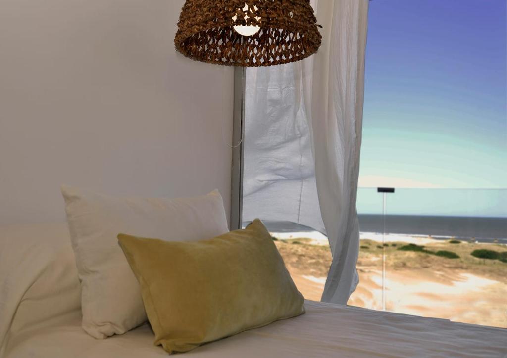 - une chambre avec un lit et une vue sur la plage dans l'établissement North Beach GHF, à Costa Esmeralda