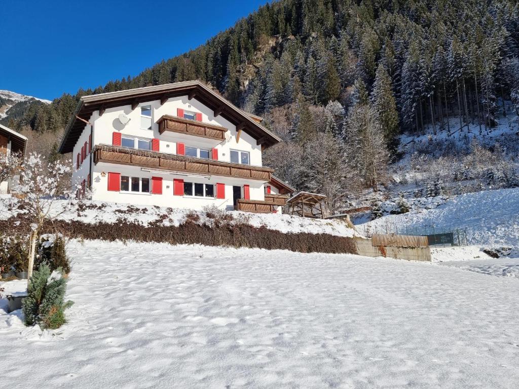 een huis aan de kant van een met sneeuw bedekte berg bij Alpenhaus Thurnher in Gaschurn