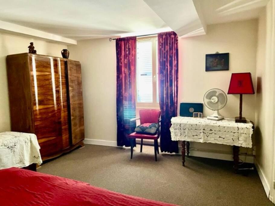 Schlafzimmer mit einem Bett, einem Schreibtisch und einem Fenster in der Unterkunft Grand family home in the heart of Burgundy! in Saint-Berain-sur-Dheune