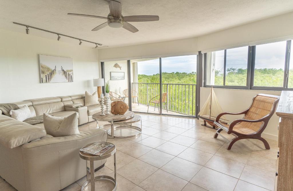 ein Wohnzimmer mit einem Sofa und einem Balkon in der Unterkunft SEA MIST - Oceanfront-Lake-Kayak-Paddleboard-Bike in Key Largo