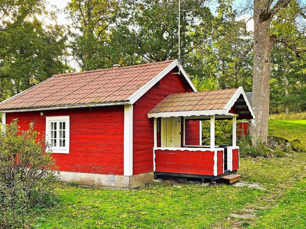 una pequeña casa roja con techo rojo en Holiday home MÖNSTERÅS VII, en Mönsterås