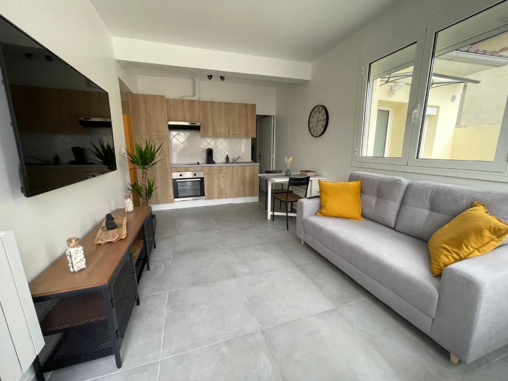 uma sala de estar com um sofá e uma cozinha em Superbe T2 proche de Paris & Disneyland em Ozoir-la-Ferrière
