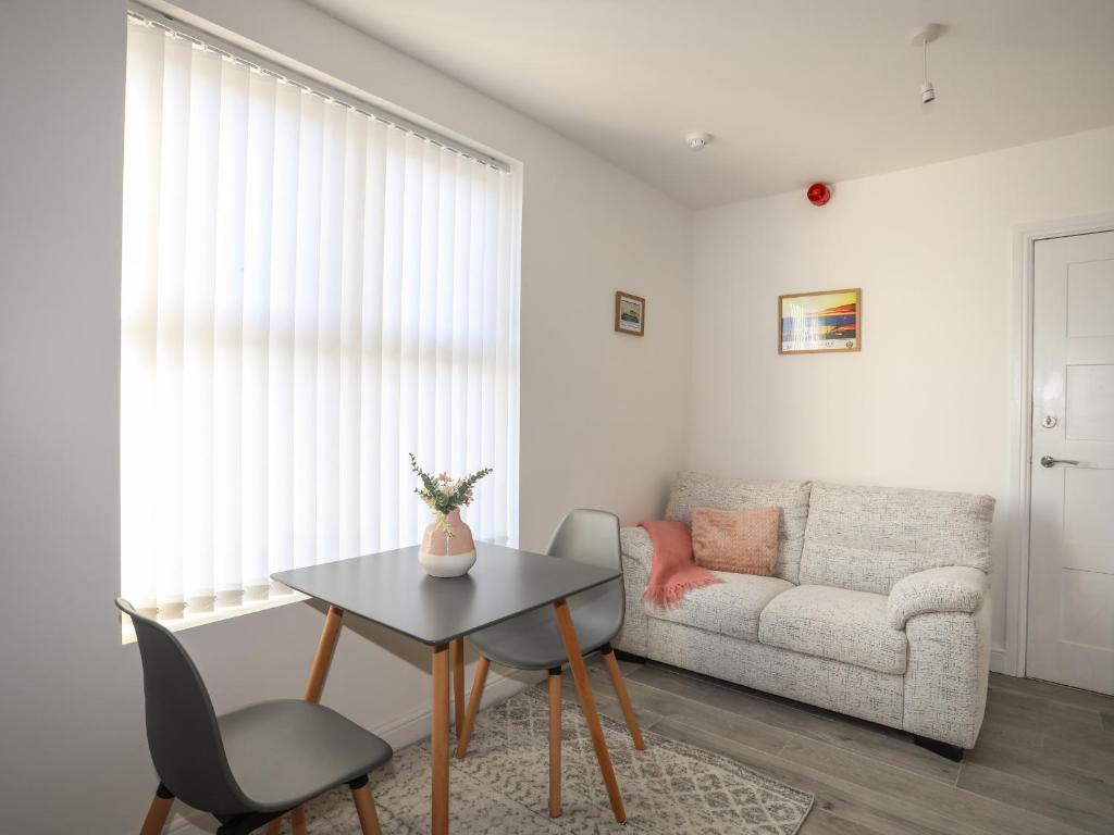 ein Wohnzimmer mit einem Tisch und einem Sofa in der Unterkunft Port Apartment 1 in Holyhead