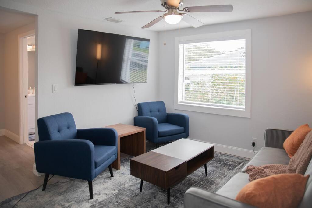 sala de estar con 2 sillas azules y TV en Patio I Firepit I 65 TV w/ Netflix I 472mbps I WD, en Vero Beach