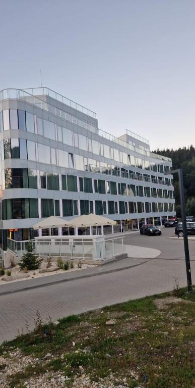 duży budynek z parkingiem przed nim w obiekcie Biala Perla Sunny Mountain 602 w mieście Sienna