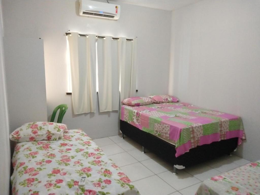 een slaapkamer met 2 bedden en een raam bij Pousada Brandão in Parnaíba