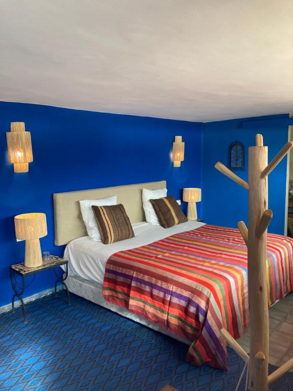 a bedroom with a bed with blue walls at Le Patio Du Lac in Lalla Takerkoust
