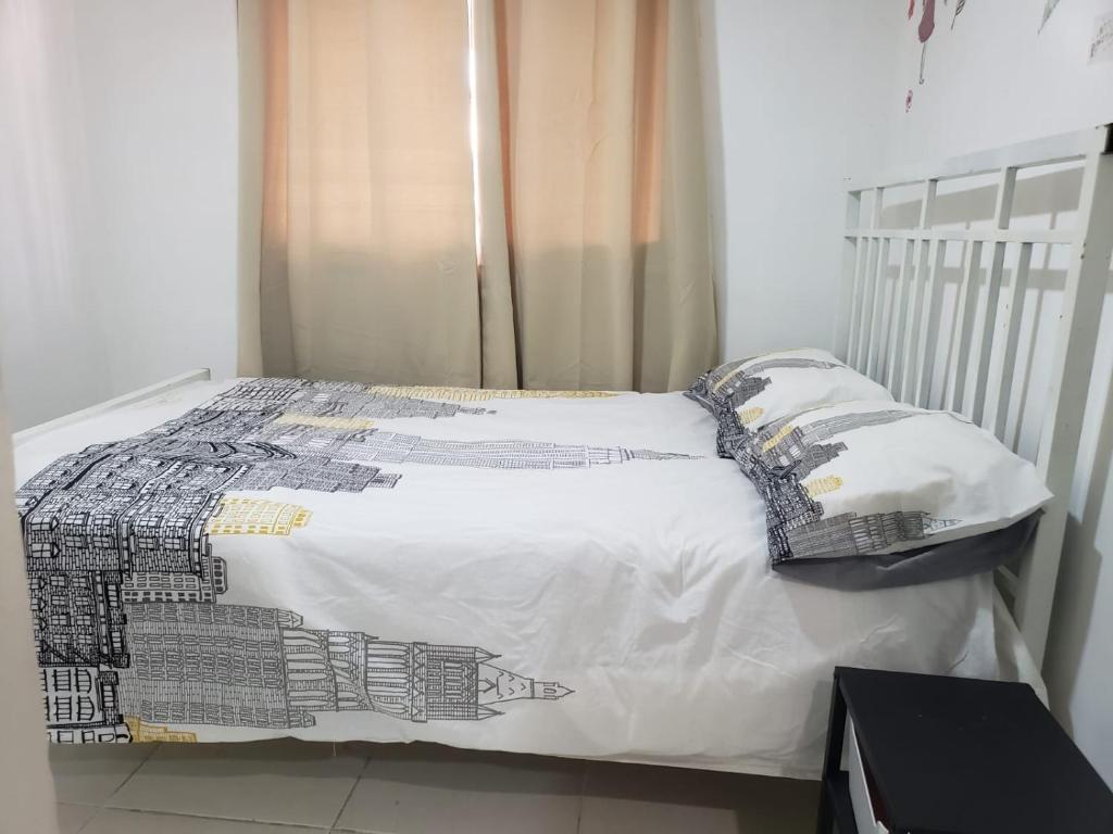 1 cama con edredón blanco y almohadas en Apartamento Familiar y tranquilo, en Pantoja