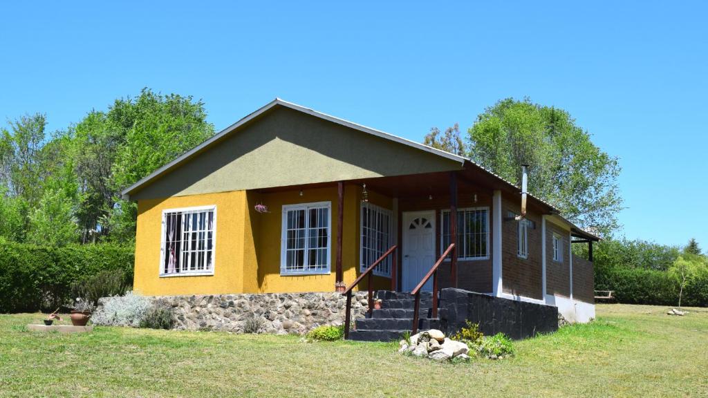 una casa con un perro tirado frente a ella en Casa Doña Nelly - Sierras, naturaleza, y descanso en Villa Yacanto