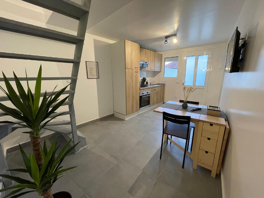 a kitchen with a table and a chair in a room at Superbe T3 Duplex proche Paris & Disneyland in Ozoir-la-Ferrière