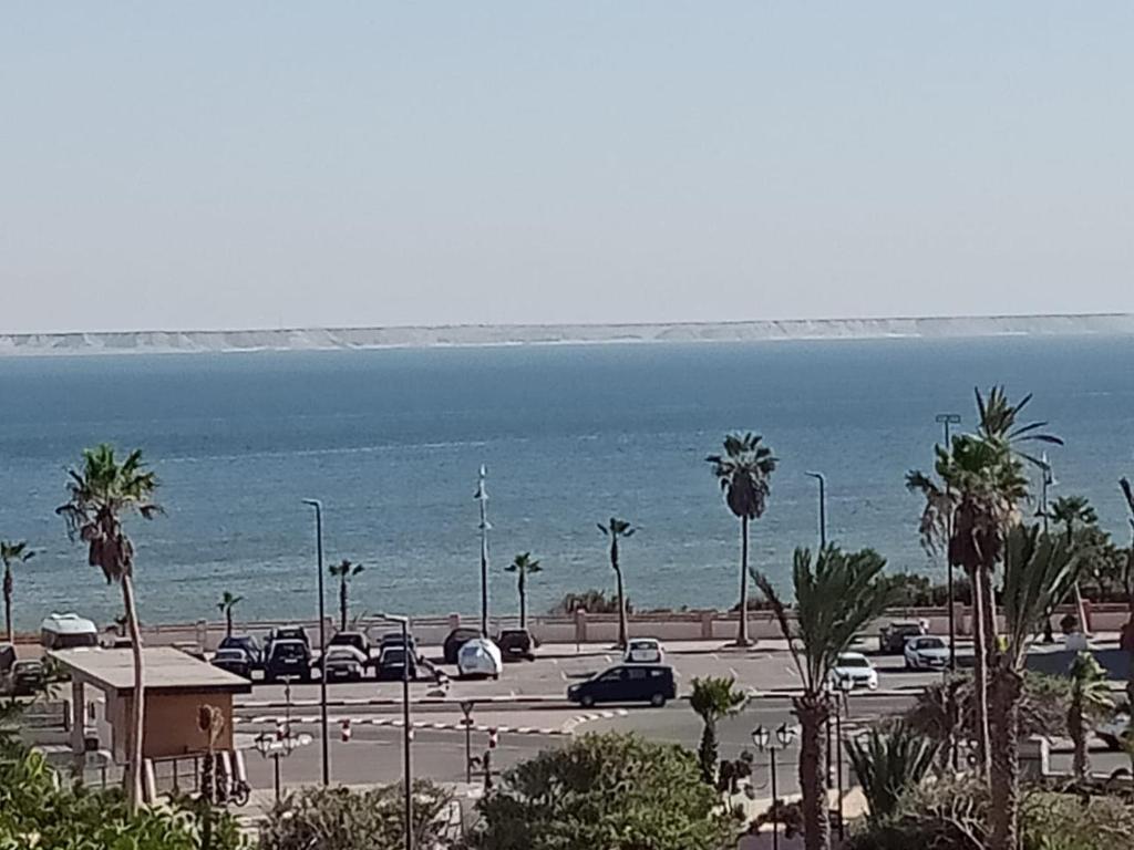 een parkeerplaats met auto's geparkeerd naast de oceaan bij Résidence hôtelière Nour in Dakhla