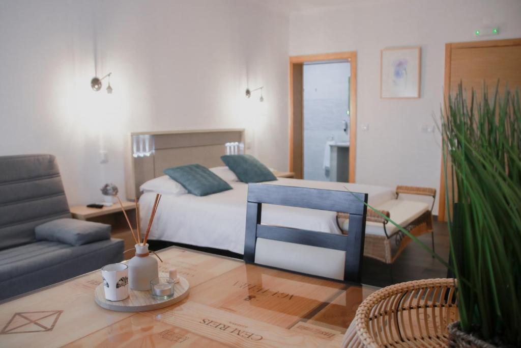坎普馬約爾的住宿－São Pedro Country House，一间卧室配有一张床、一张沙发和一张桌子