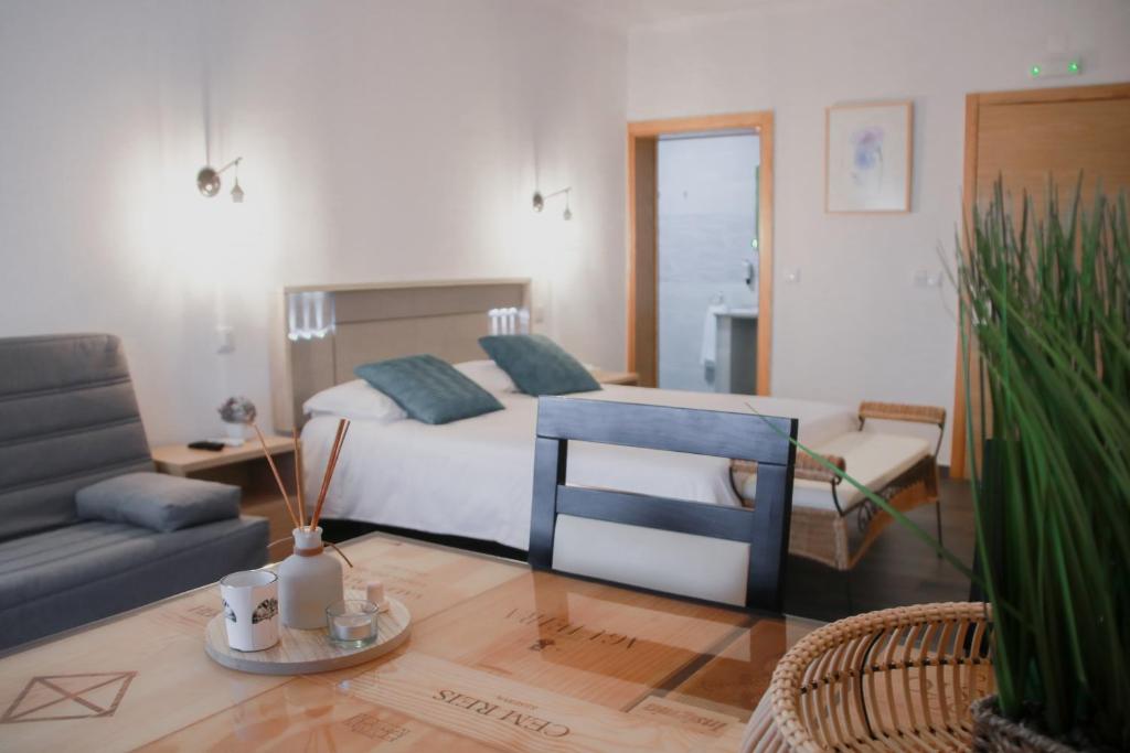 a bedroom with a bed and a couch and a table at São Pedro Country House in Campo Maior