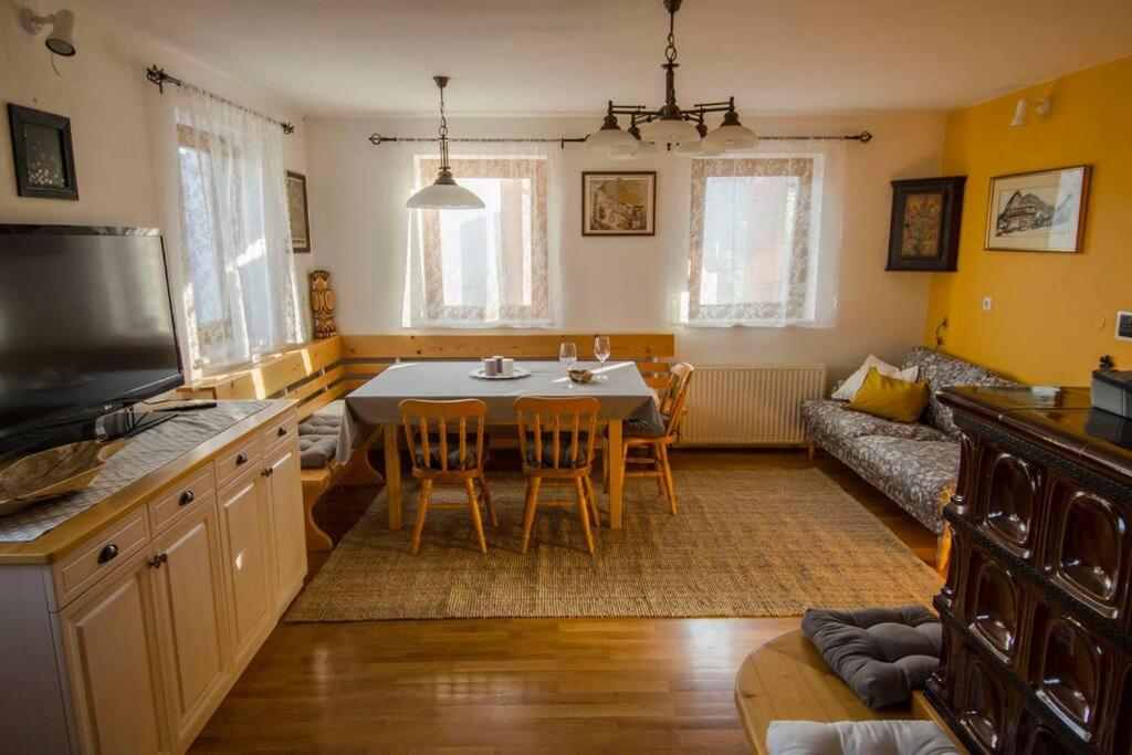 een keuken en een woonkamer met een tafel en een bank bij House Pucnk-beautiful countryside in Železniki