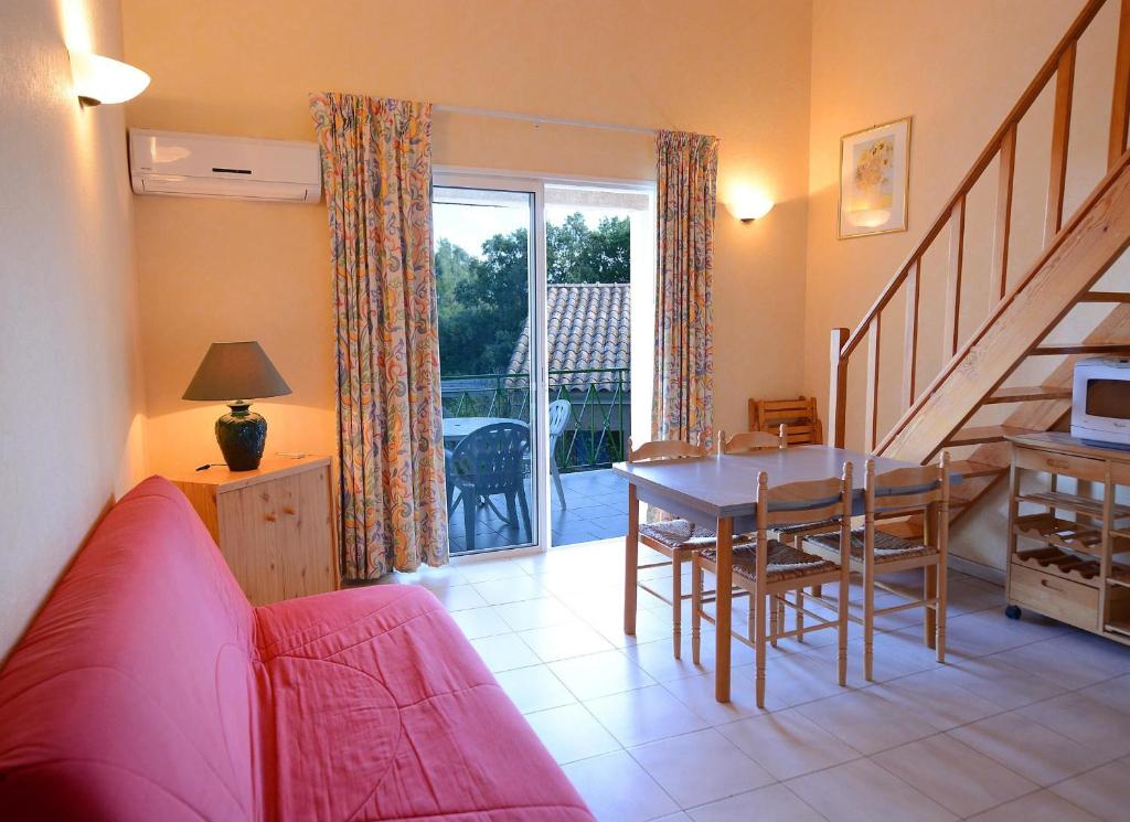 a living room with a red couch and a table at Résidence Fior di Rena in Saint-Florent