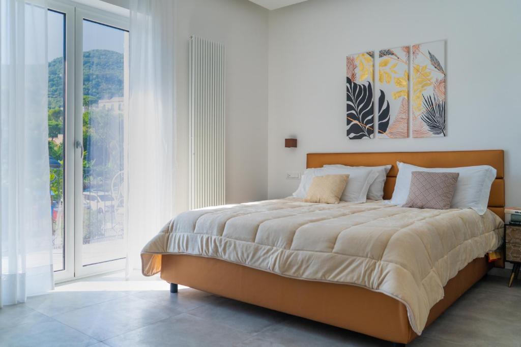 a bedroom with a large bed and a large window at Alloggio nuovissimo al centro e rilassante in Ischia